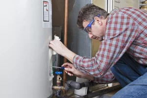 a plumber preforming maintenance on a residential water heater