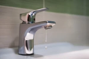 leaky faucet in green bathroom