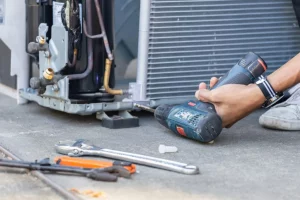 a hand with a drill working on repairing equiptment